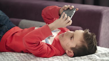 男孩玩移动游戏智能手机沙发孩子玩移动<strong>电话</strong>